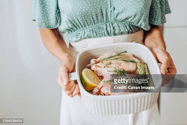 close up hands holding a tray with raw quail and aromatic herbs - paleo diet stock pictures, royalty-free photos & images