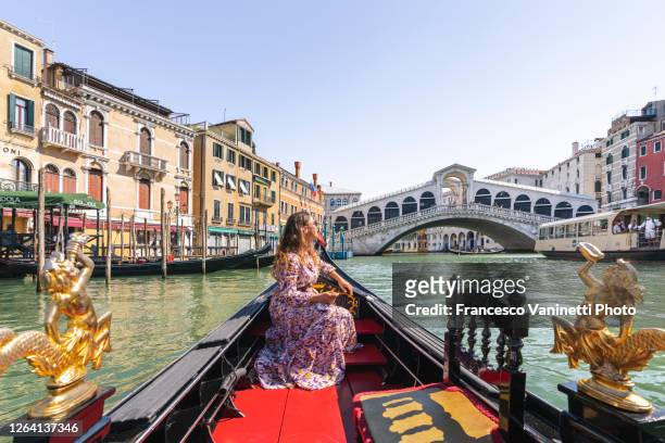 woman on gondola and rialto bridge, venice. - venice italy stock pictures, royalty-free photos & images