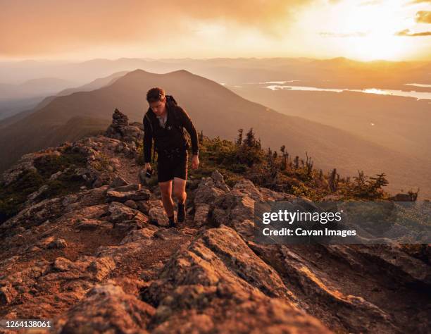 male hiker walks along appalachian trail on bigelow mountain at sunset - appalachian trail fotografías e imágenes de stock