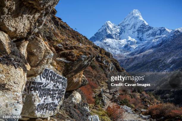 buddhist script below the peak of ama dablam on the trail to everest. - mt everest base camp stock pictures, royalty-free photos & images