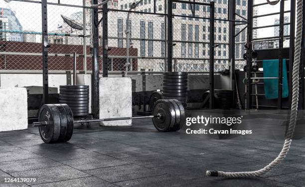 barbell and weights  at empty rooftop gym in bangkok - crossfit photos et images de collection