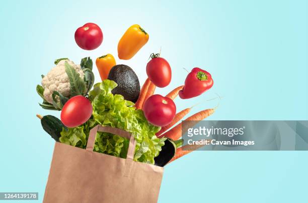 recyclable bag of fresh vegetables on blue summer sky background - bio supermarkt stock-fotos und bilder