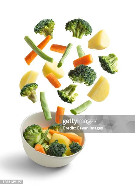 boiled vegetables flying on white background. creative concept - ingredients on white ストックフォトと画像