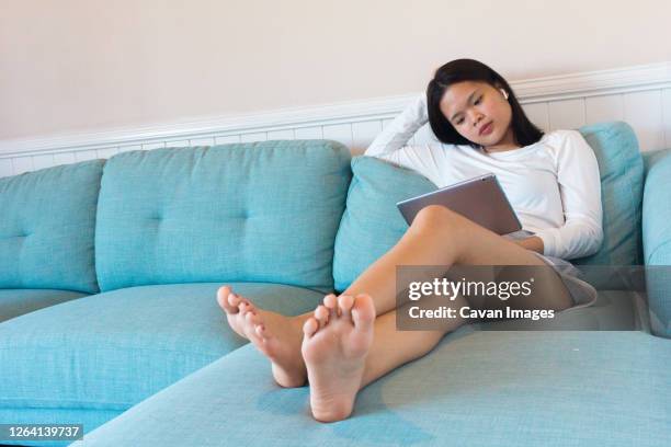 young asian woman study with tablet at home - teen girl barefoot at home stock pictures, royalty-free photos & images