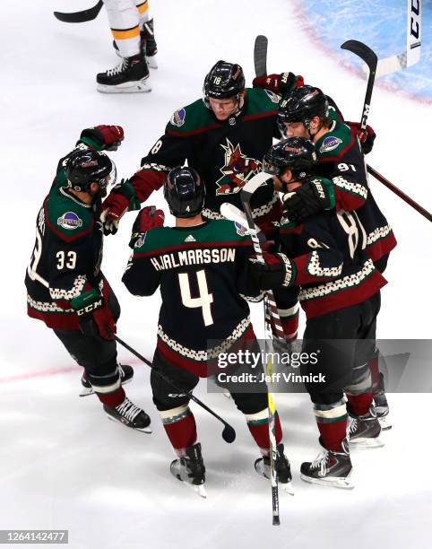 Christian Dvorak of the Arizona Coyotes is congratulated by teammates Alex Goligoski,Niklas Hjalmarsson,Phil Kessel and Taylor Hall after Dvorak...