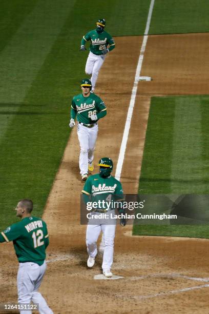 Oakland Athletics base runners Franklin Barreto, Matt Chapman and Mark Canha round the bases to score on a walk-off grand slam hit by Stephen...