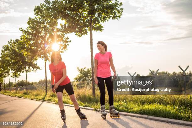 twee wijfjes inline het schaatsen - skaten stockfoto's en -beelden