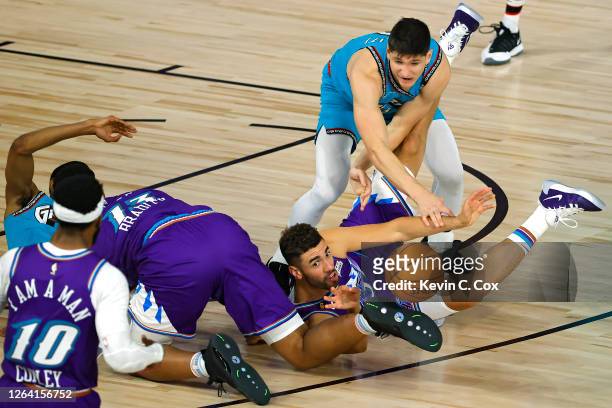 Georges Niang of the Utah Jazz grabs a loose ball in front of Grayson Allen and De'Anthony Melton of the Memphis Grizzlies during the second half at...