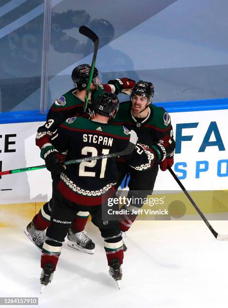 Conor Garland of the Arizona Coyotes celebrates with teammates Oliver Ekman-Larsson and Derek Stepan after Garland scored in the third period against...