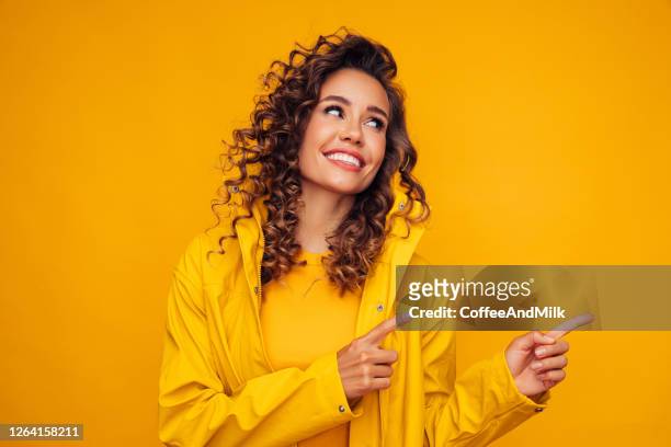 lächelnde schöne frau - gelber hintergrund stock-fotos und bilder