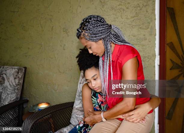 african american mother and daughter sitting together outdoors on front porch - african girl hug stock pictures, royalty-free photos & images