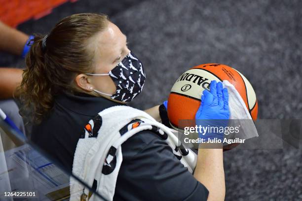 Staff member sanitizes a game ball that went out of bounds during a game between the Indiana Fever and the Atlanta Dream at Feld Entertainment Center...