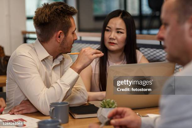 multicultural office employees having a business meeting - round table discussion stock pictures, royalty-free photos & images