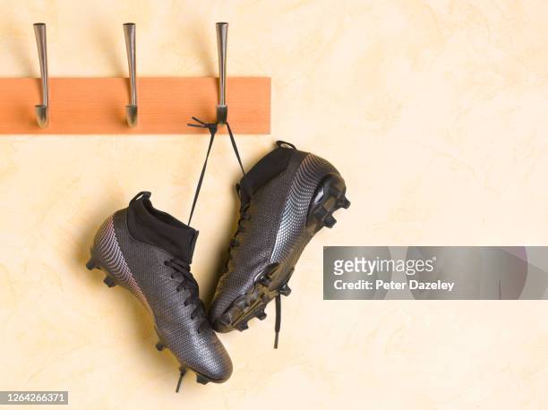soccer boots hanging up in locker room - chuteira imagens e fotografias de stock