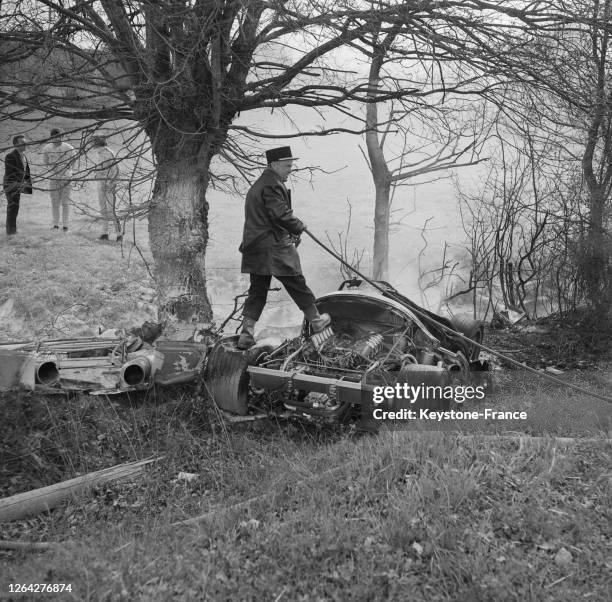 Un pompier éteint l'incendie de la voiture accidentée du pilote Henri Pescarolo le 16 avril 1969 au Mans, France.