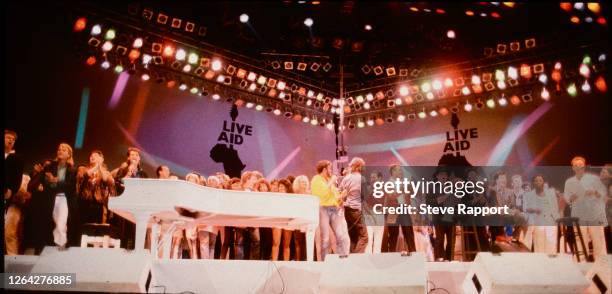 View of performs onstage for the finale of the Live Aid benefit concert, Wembley Stadium, London, 7/13/1985.