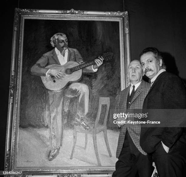 Le peintre Yves Brayer présente à Georges Brassens le portrait qu'il a fait de lui pour l'exposition 'Les Peintres témoins de leur temps' le 18...