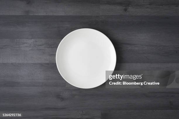 white plate on dark background - wood dish stock pictures, royalty-free photos & images