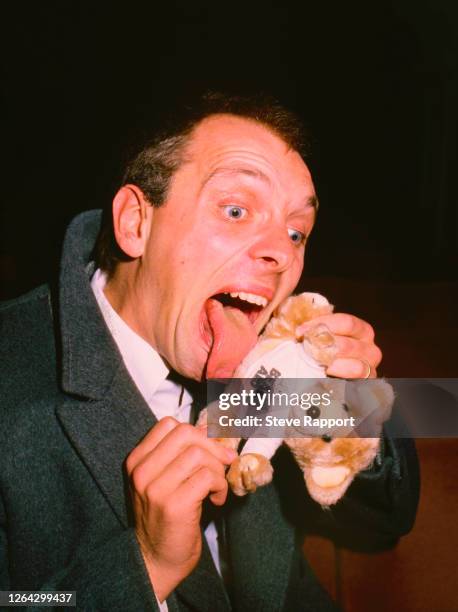 British comedian and actor Rik Mayall licks a toy bear at the Bear Aid/Comic Relief, Shaftesbury Theatre, London, 4/25/1986.