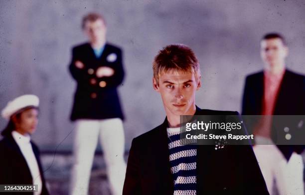 English Pop and Rock musician Paul Weller, of the group the Style Council, films the music video for 'The Lodger,' 9/2/1985. Behind him, from left,...