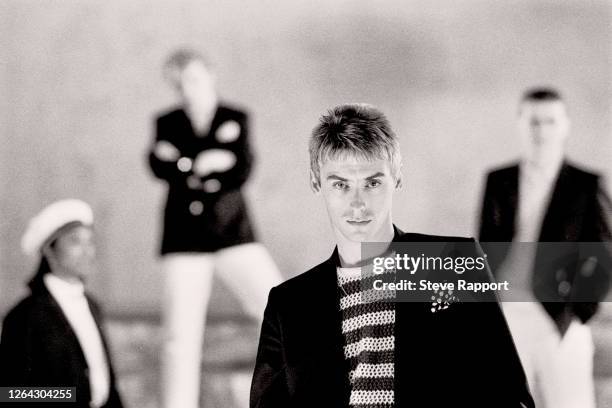 English Pop and Rock musician Paul Weller, of the group the Style Council, films the music video for 'The Lodger,' 9/2/1985. Behind him, from left,...