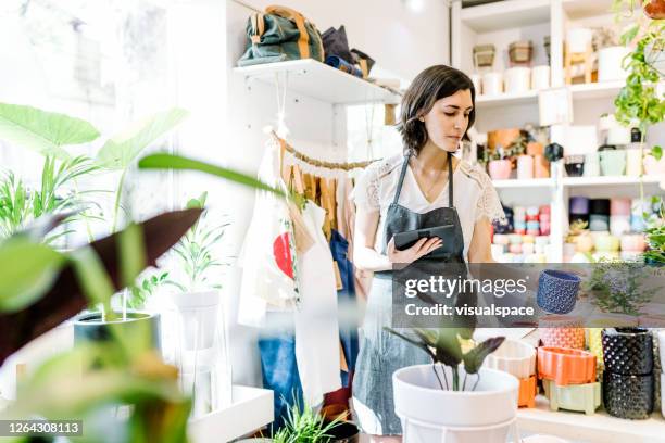 trabajador de la floristería usando la tableta digital - tienda de regalos fotografías e imágenes de stock