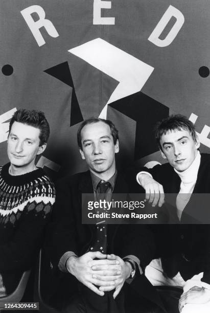 View of, from left, English musician Billy Bragg, journalist Neil Spencer, and musician Paul Weller with the Red Wedge red flag, 11/1/1985. During...