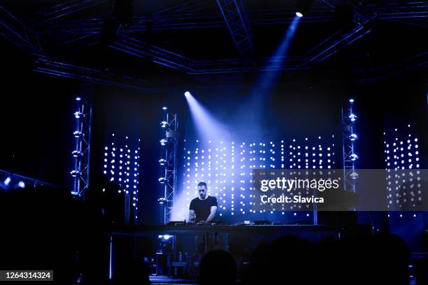 dj tocando música techno en el escenario - dj fotografías e imágenes de stock