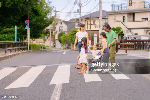 family taking a walk around their neighborhood in city - cross road children stock pictures, royalty-free photos & images