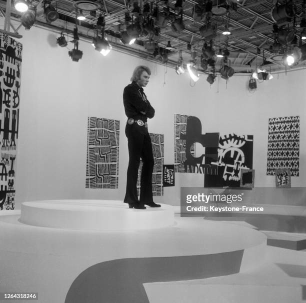 Johnny Hallyday en chemise de soie et pantalon à pattes d'éléphant pendant l'enregistrement d'une émission télévisée, à Paris, France le 7 janvier...
