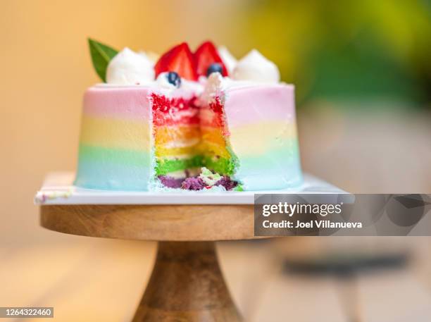 delicious rainbow birthday cake topped with berries. - fancy cupcake stock pictures, royalty-free photos & images