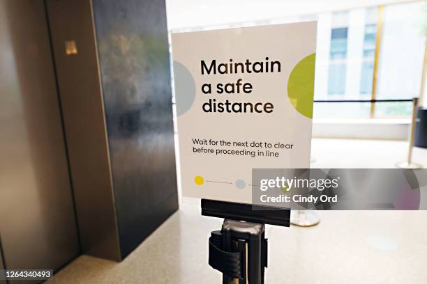 Sign reminding visitors to maintain a safe distance is displayed at the entrance to elevators at Top of the Rock Observation Deck as it reopens to...