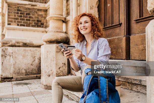 female tourist with backpack shopping online - travel credit card stock pictures, royalty-free photos & images