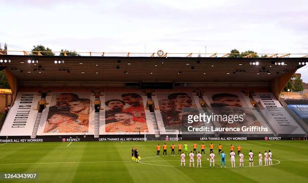 Players and officials take part in a minutes silence for those effected by the Coronavirus during the UEFA Europa League round of 16 second leg match...