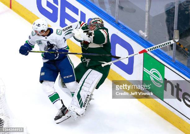 Antoine Roussel of the Vancouver Canucks and Alex Stalock of the Minnesota Wild collide behind the net in the first period in Game Three of the...