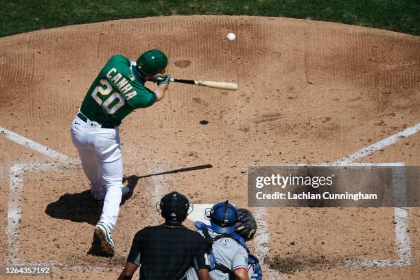 Mark Canha of the Oakland Athletics hits an RBI single in the bottom of the fourth inning against the Texas Rangers at Oakland-Alameda County...