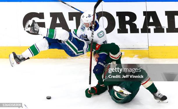 Joel Eriksson Ek of the Minnesota Wild is called for holding on this play as he takes down Loui Eriksson of the Vancouver Canucks in the third period...