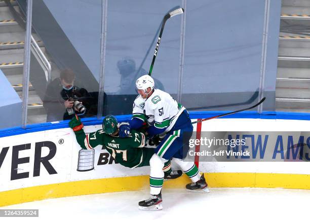 Tyler Myers of the Vancouver Canucks shoves Brad Hunt of the Minnesota Wild to the ice in the third period in Game Three of the Western Conference...