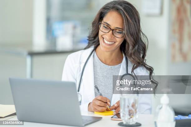 healthcare professional on a remote video telemedicine call - doctor laptop stock pictures, royalty-free photos & images
