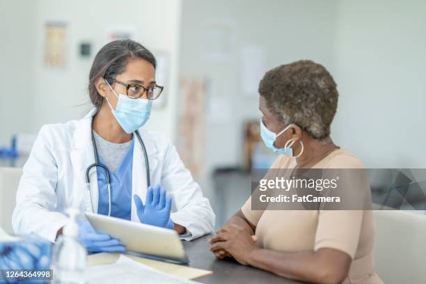 doctor and patient in medical exam - black glove stock pictures, royalty-free photos & images