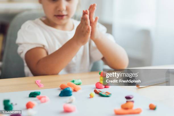 activités préscolaires : mains d’une petite fille jouant avec la plasticine faisant des formes et des animaux, un close up - clay photos et images de collection