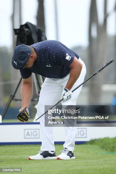 Bryson DeChambeau of the United States picks up his the head of his broken driver on the seventh tee during the first round of the 2020 PGA...