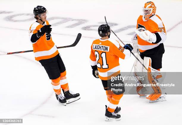 Brian Elliott of the Philadelphia Flyers celebrates with Scott Laughton and Philippe Myers after defeating the Washington Capitals in the Eastern...