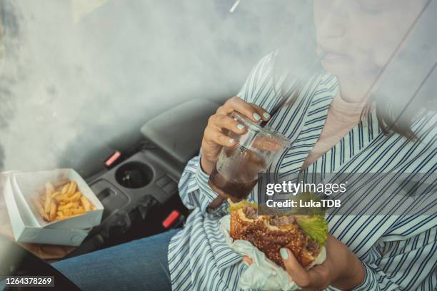 never hungry on the road - drinking soda in car stock pictures, royalty-free photos & images