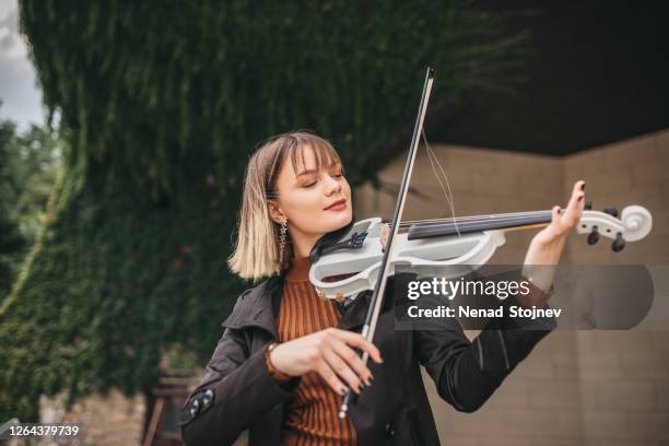 young woman violinist player during presentation - classical musician stock pictures, royalty-free photos & images