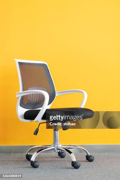 office chair in front of yellow background - office chair stock pictures, royalty-free photos & images