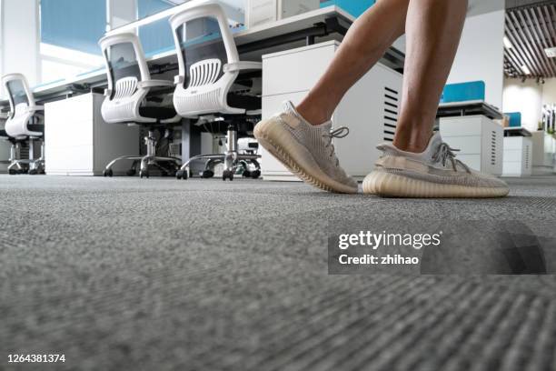 low angle view of human feet walking on office floor - office carpet stock pictures, royalty-free photos & images