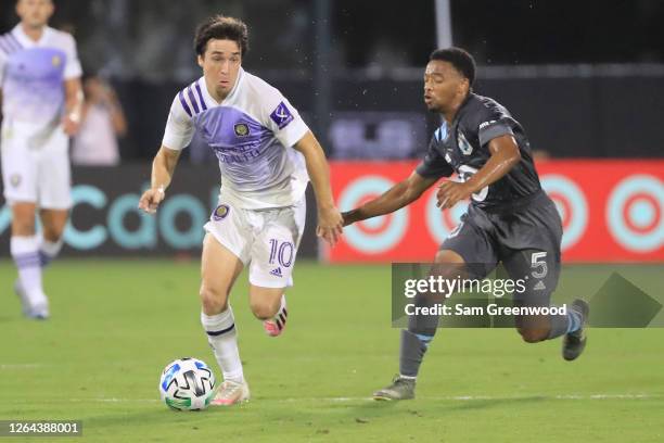 Mauricio Pereyra of Orlando City fights for the ball with Jacori Hayes of Minnesota United during a semifinal match of MLS Is Back Tournament between...