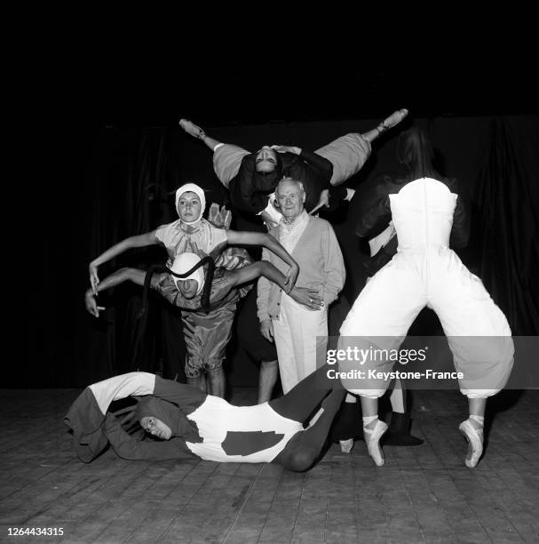 Sourire aux lèvres parmi les danseurs, le peintre Miro examine les costumes qu'il a crées pour la troupe Lazzini, à Marseille, France le 24 juillet...