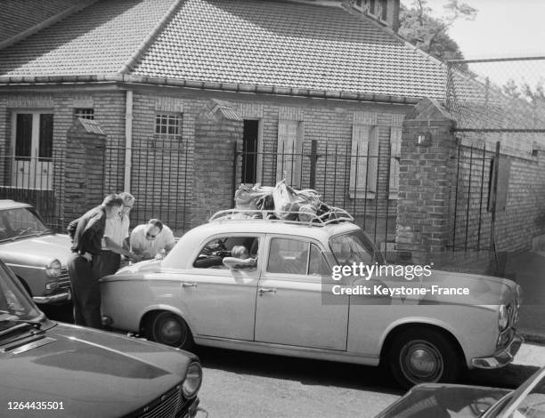 Une voiture surchargée garée, les occupants éttudient une carte pour contourner les embouteillages de rentrée, en France le 11 septembre 1968.